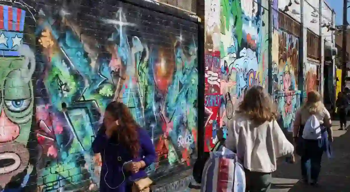 People strolling through Clarion Alley with famous Mission murals on the walls in San Francisco, United States of America