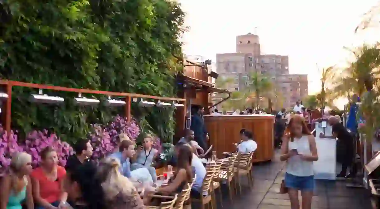 Tourists and New Yorkers doing an aperitif on the 230 Fifth rooftop. It is the first Rooftop Bar in New York.