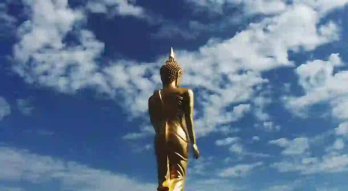 The golden walking Buddha statue at Wat Phra That Khao Noi is an essential stop in Nan