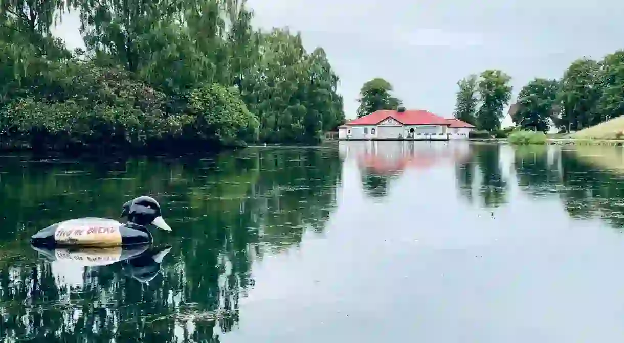 Reflection of the boathouse on the pond at Rouken Glen park, Glasgow