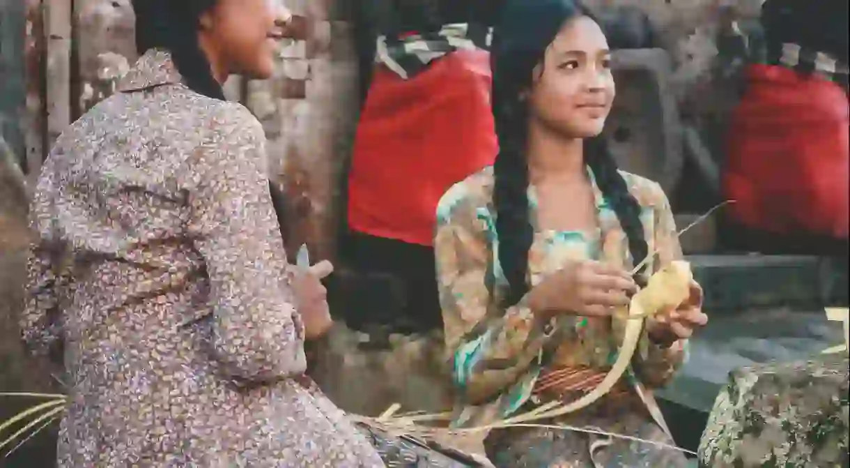 Two Indonesian girls making traditional Indonesian dish in Tenganan, Indonesia