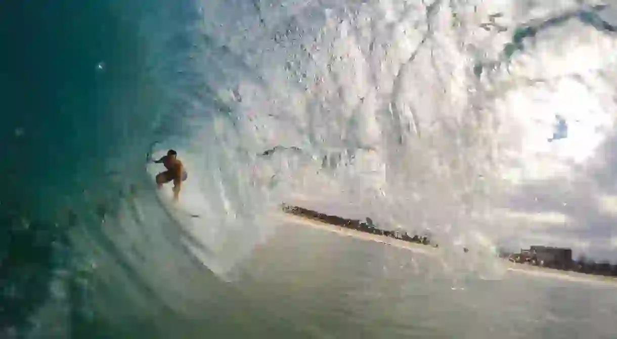 Surfer under a wave