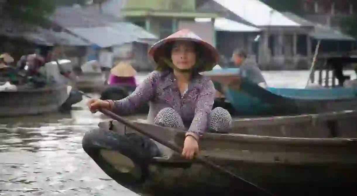 A girl in a floating market, Vietnam. One of the many memorable sights you can experience in September.