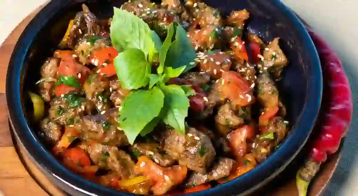 Eggplant, tomato, vegetable salad on the wooden plate