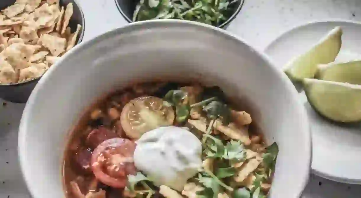 Mexican chicken tortilla soup with condiments and toppings