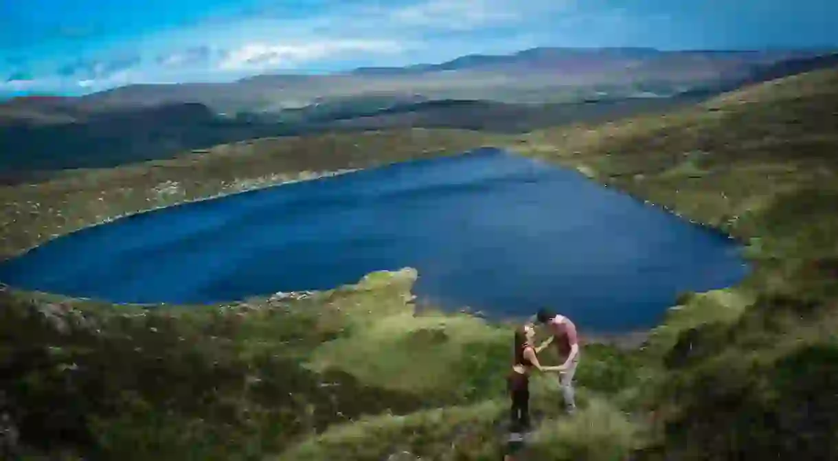 Couple holding hands at Irelands hear shaped lake, Lough Ouler, Wicklow, Ireland