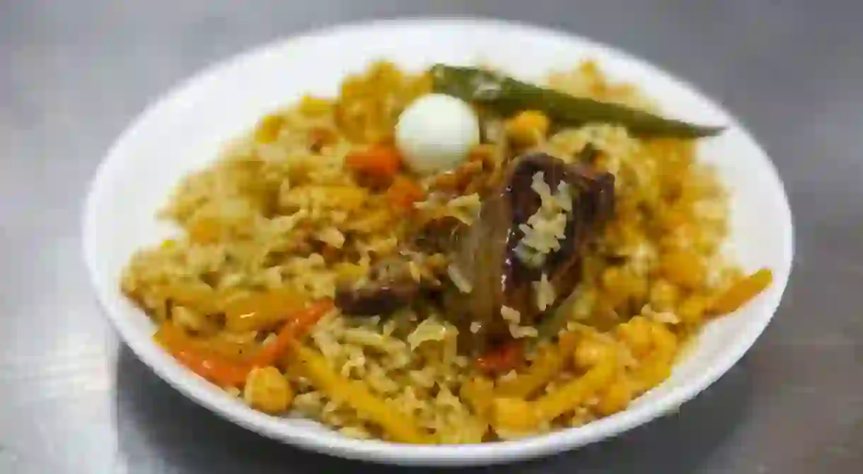 Traditional central Asian dish - pilaf from rice, vegetables, and beef on a plate