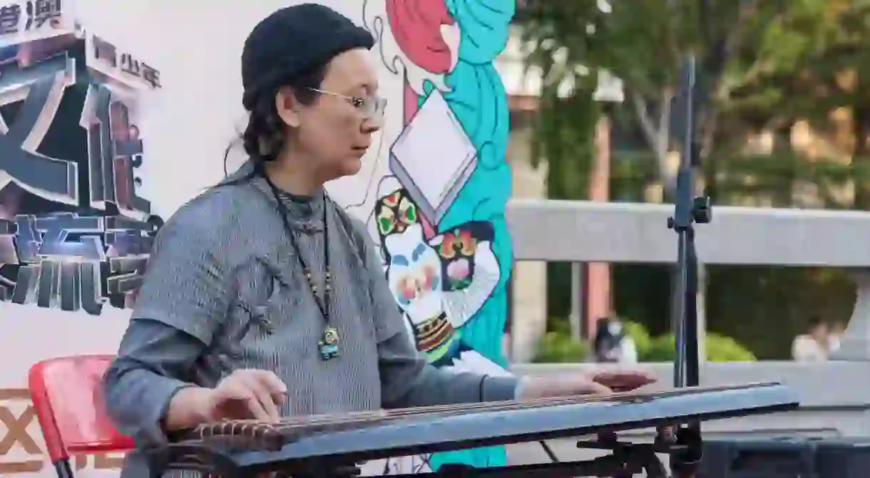 A woman playing guqin, a traditional Chinese instrument