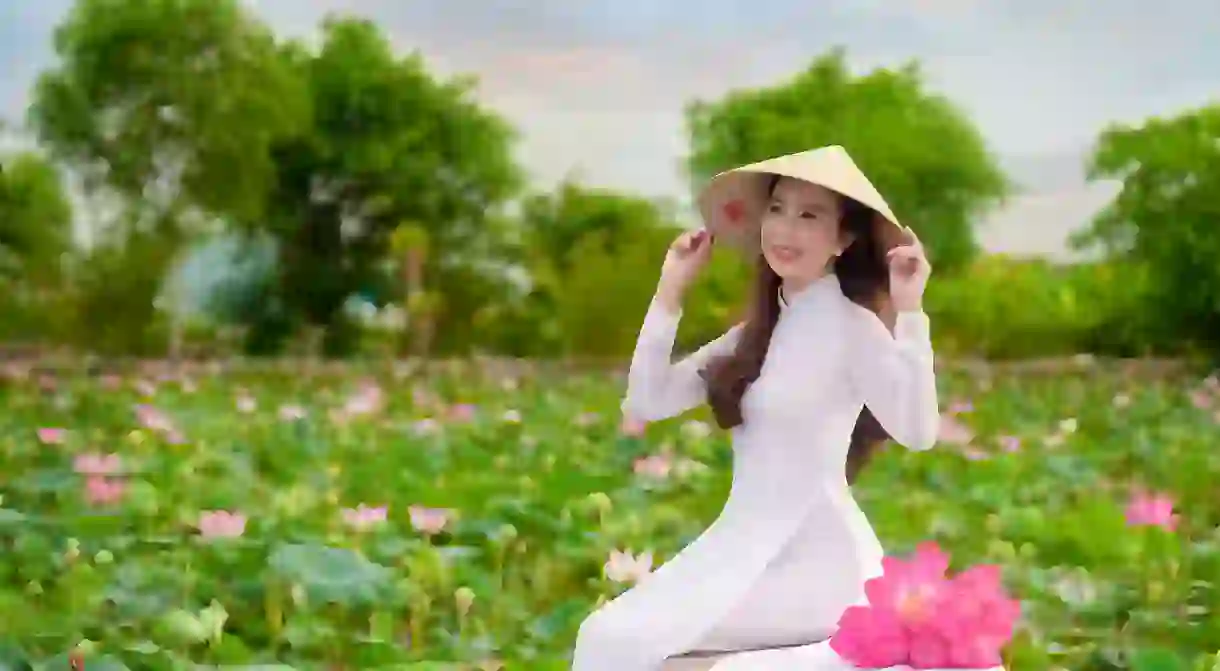 Vietnamese woman wearing Ao Dai and conical hat