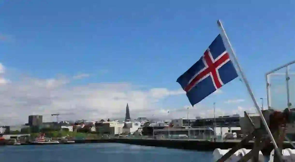 View on city Reykjavik in Iceland from boat with Iceland flag.