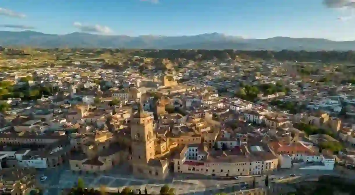 Aerial view of city center of Guadix, Spain. Beautiful warm colours at sunset. Cathedral of Guadix in the middle of the city. Travel destination in Granada Province. Sierra Nevada Mountain.