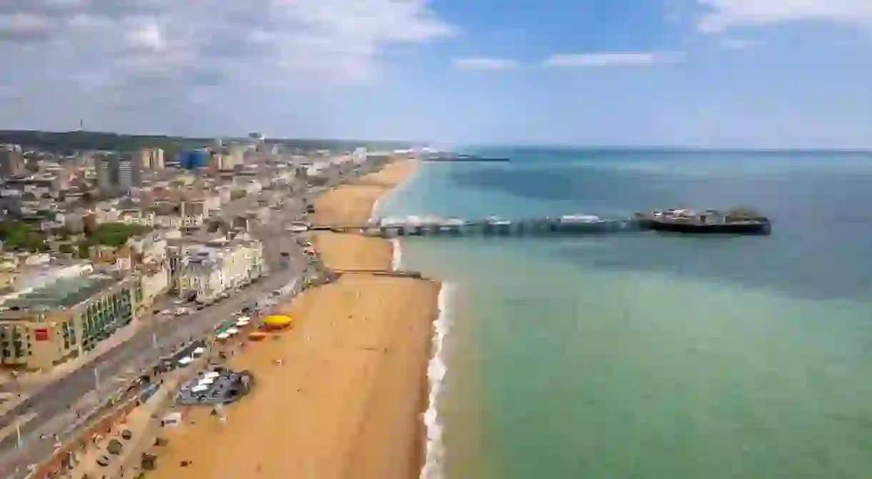 The drone aerial view of Brighton Pier and the beach of Brighton. The Brighton Palace Pier, is a pleasure pier in Brighton, England, located in the city centre opposite the Old Steine.