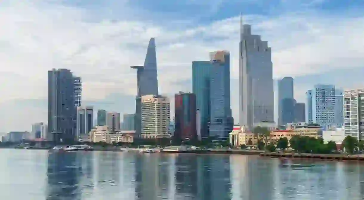 Awesome Ho Chi Minh City skyline. Amazing view of skyscrapers and other high-rise buildings reflected in water of the Saigon River at downtown of Ho Chi Minh City, Vietnam. Scenic cityscape.