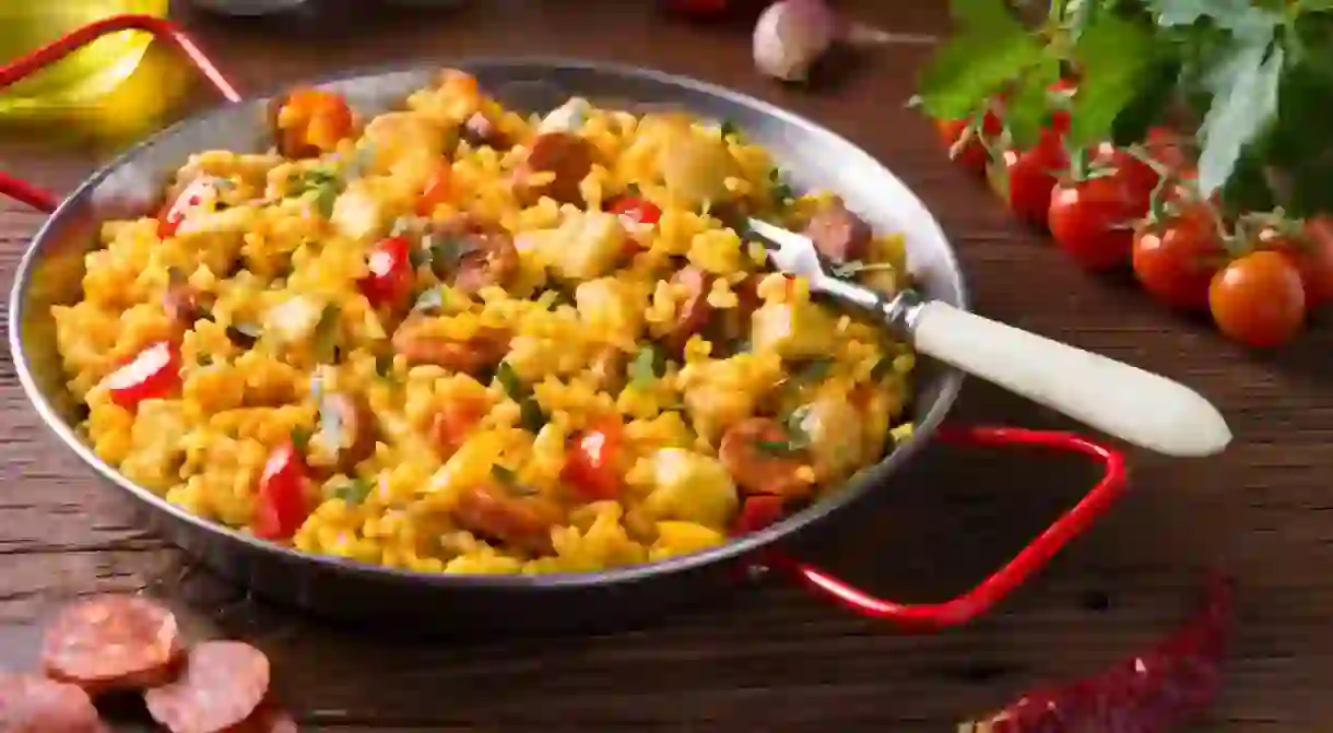 Traditional Spanish Paella with chicken. Wooden background.