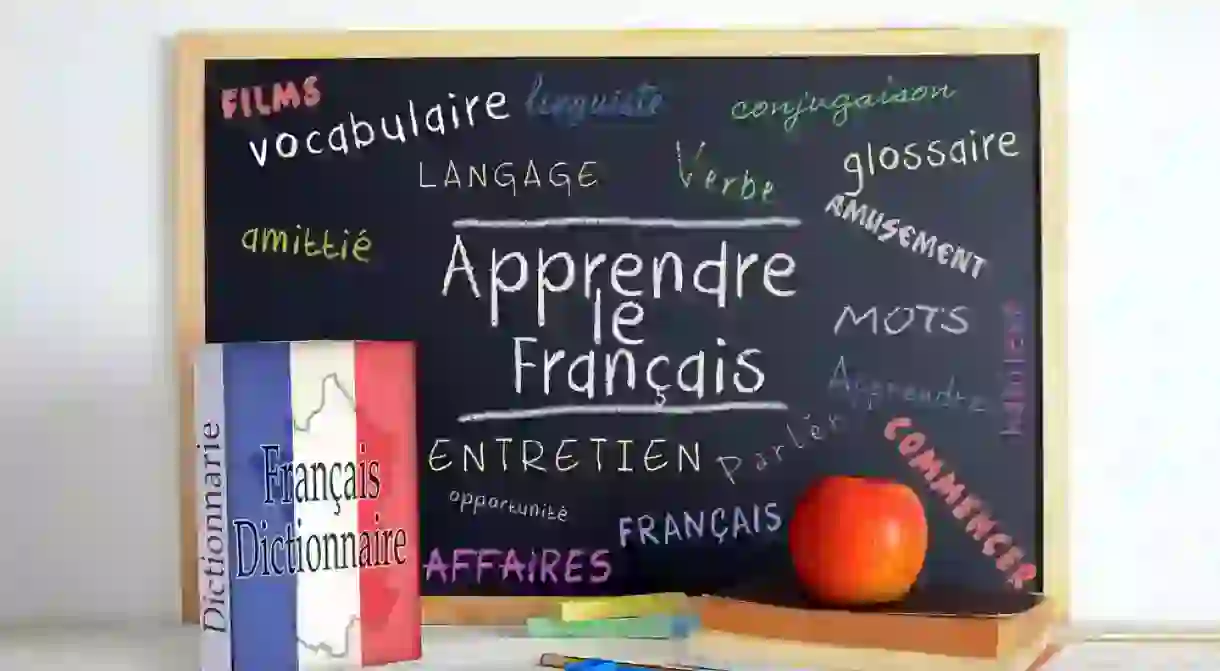 Blackboard with the message LEARN FRENCH and some text