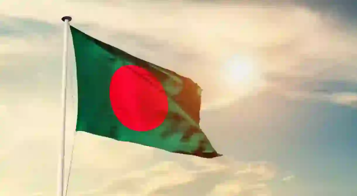 Bangladesh national flag cloth fabric waving on the sky with beautiful sunlight