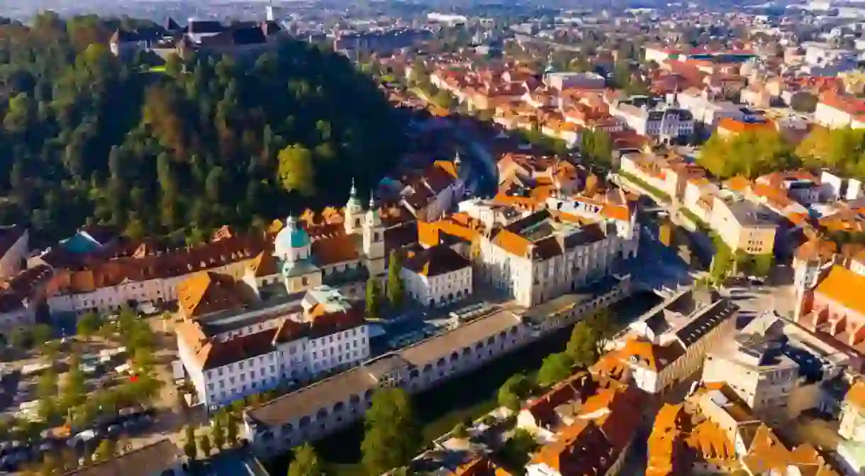 Panoramic aerial view of Ljubljana downtown with ancient castle complex on hilltop in sunny autumn morning, Slovenia