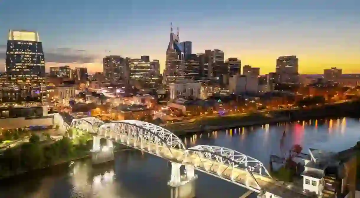 Nashville, Tennessee, USA skyline over the Cumberland River at golden hour.