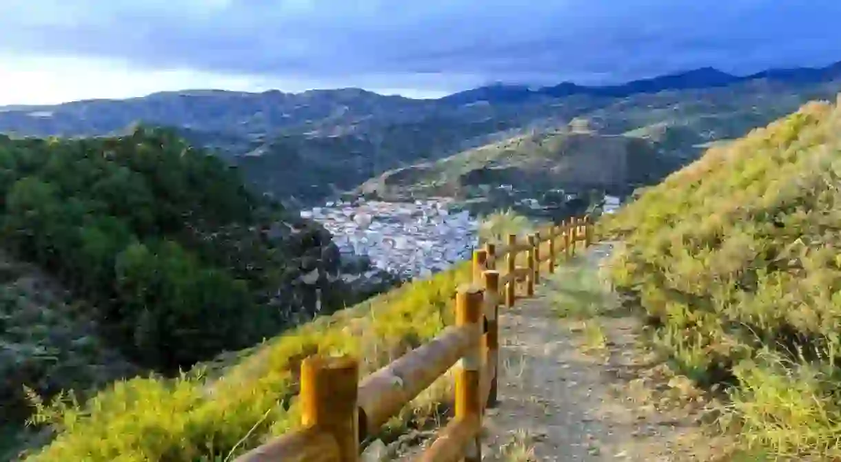 Horizontal shot of a hiking trail overlooking Quéntar, a traditional white village in the Sierra Nevada mountains near Granada