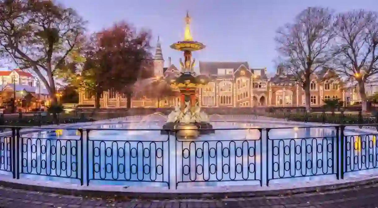 The restored Peacock Fountain in Christchurch Botanic Gardens at twilight with the Arts Centre