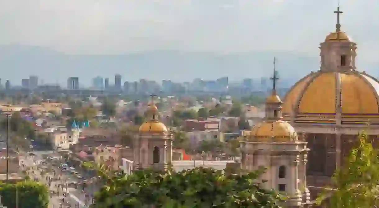 Old Basilica of Guadalupe with Mexico City skyline behind it