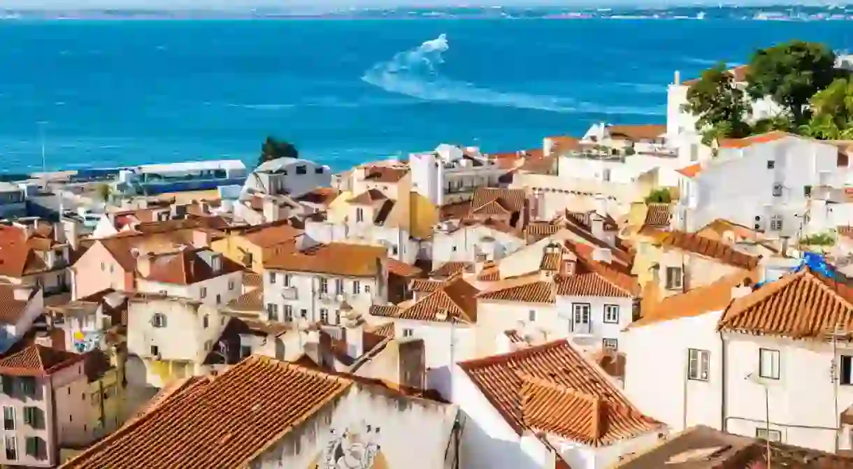 View of Lisbon old town Alfama district with houses clay orange roofs from viewpoint Portas do Sol, Lisbon, Portugal