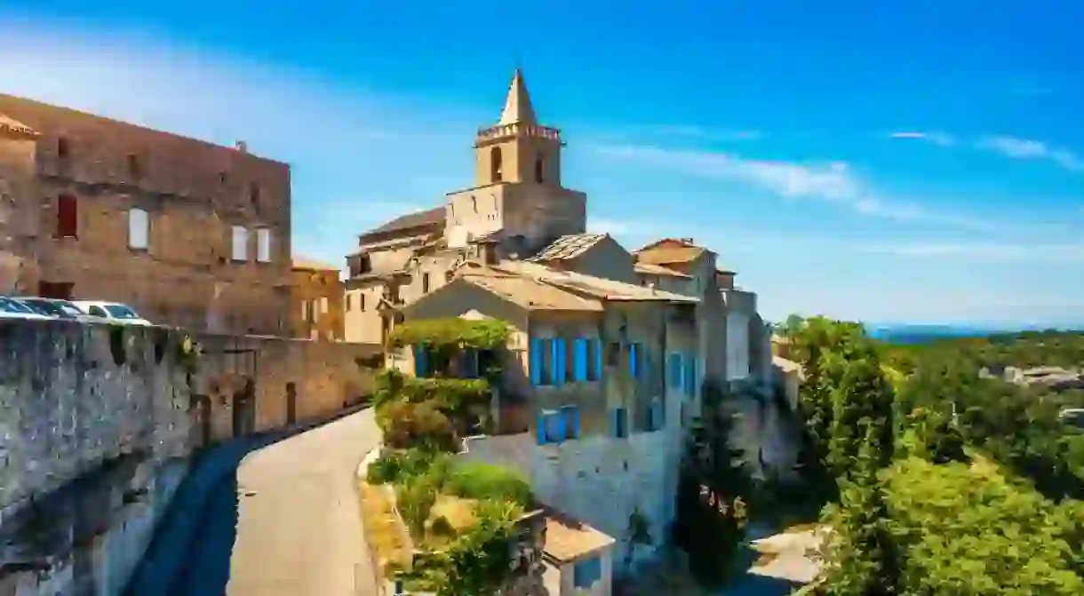 View of Venasque village with old church Notre Dame de Vie to landscape of Luberons, Provence, France