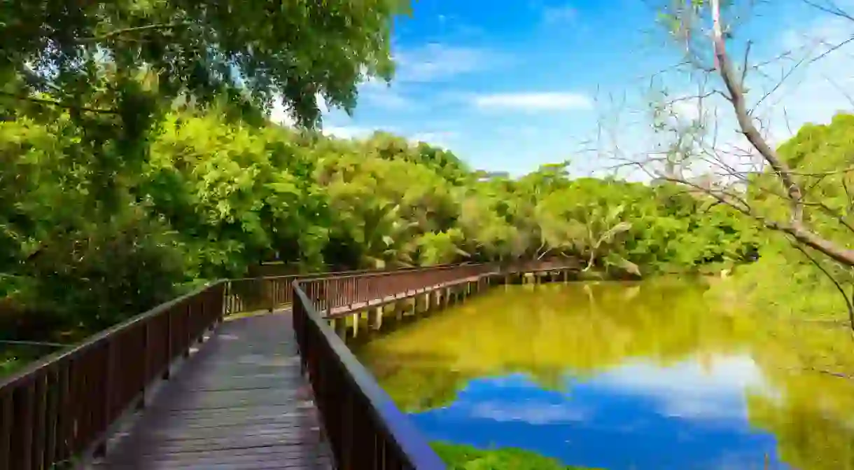 Wooden bridge walkway in Sri Nakhon Khuean Khan Park and Botanical Garden.