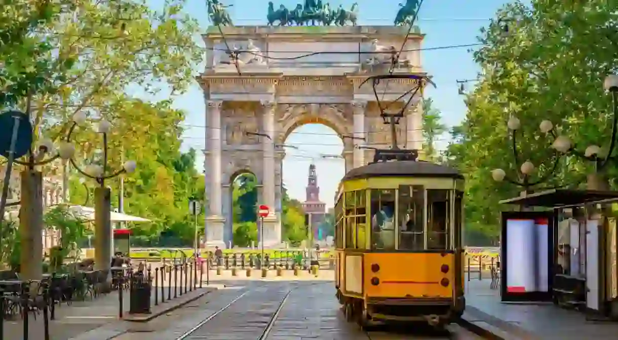 View of the Peace Arch with yellow tram in Milan, Italy