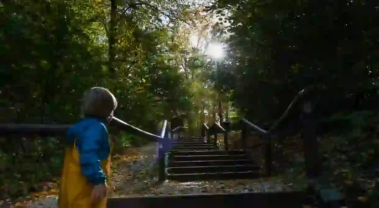 Little boy looking up to the end of the stairs and towards the sun