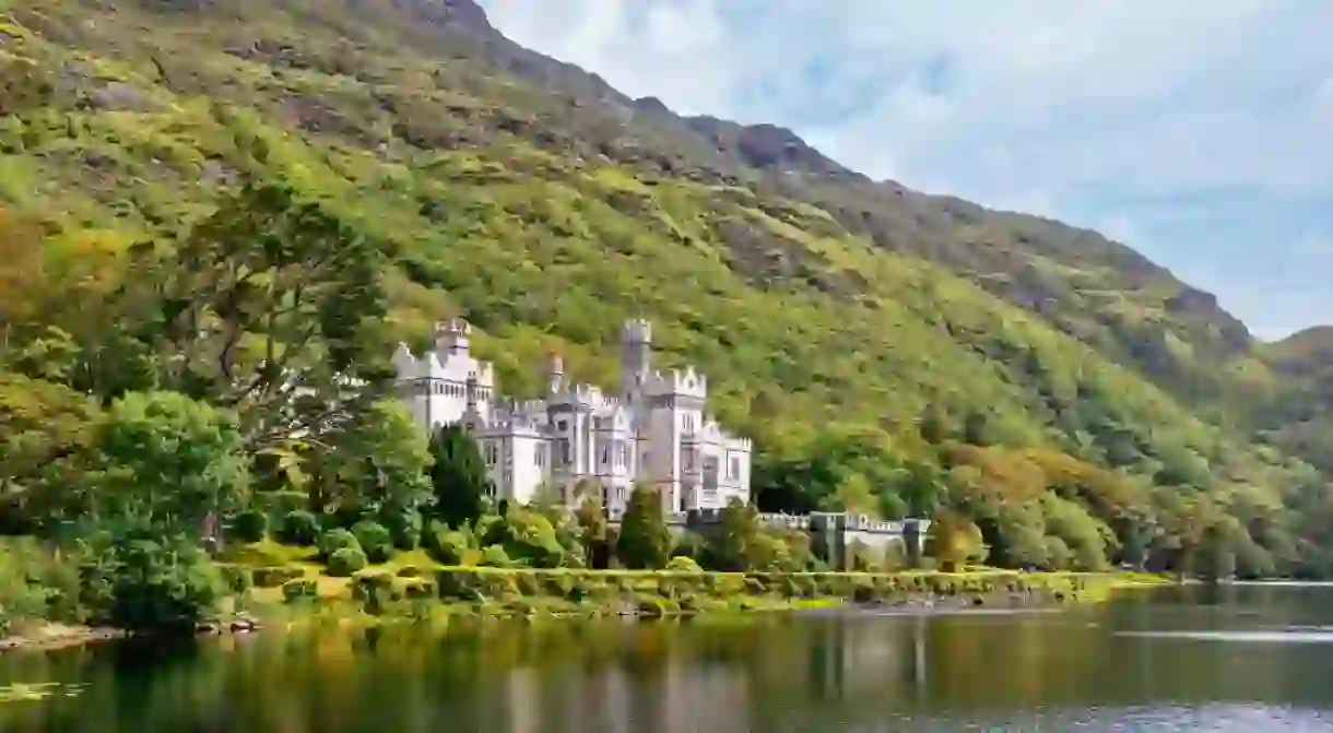 Kylemore Abbey with water reflections in Connemara, County Galway, Ireland, Europe. Benedictine monastery founded 1920 on the grounds of Kylemore Castle. Mainistir na Coille Moire