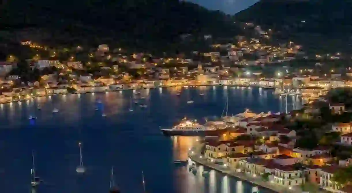 Night view with a full moon of the picturesque port of Vathy village, the capital of Ithaca island, Ionian, Greece.